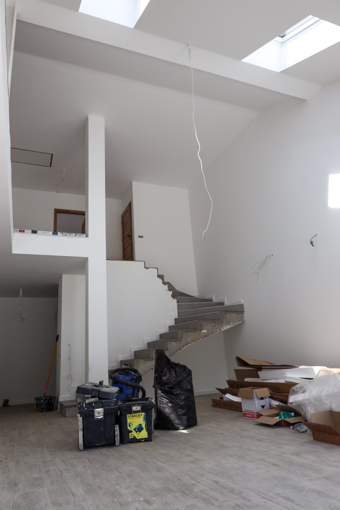 1. kép – Lenyűgöző belmagasság és egyedi monolit beton lépcsőszerkezet a tágas nappaliban..